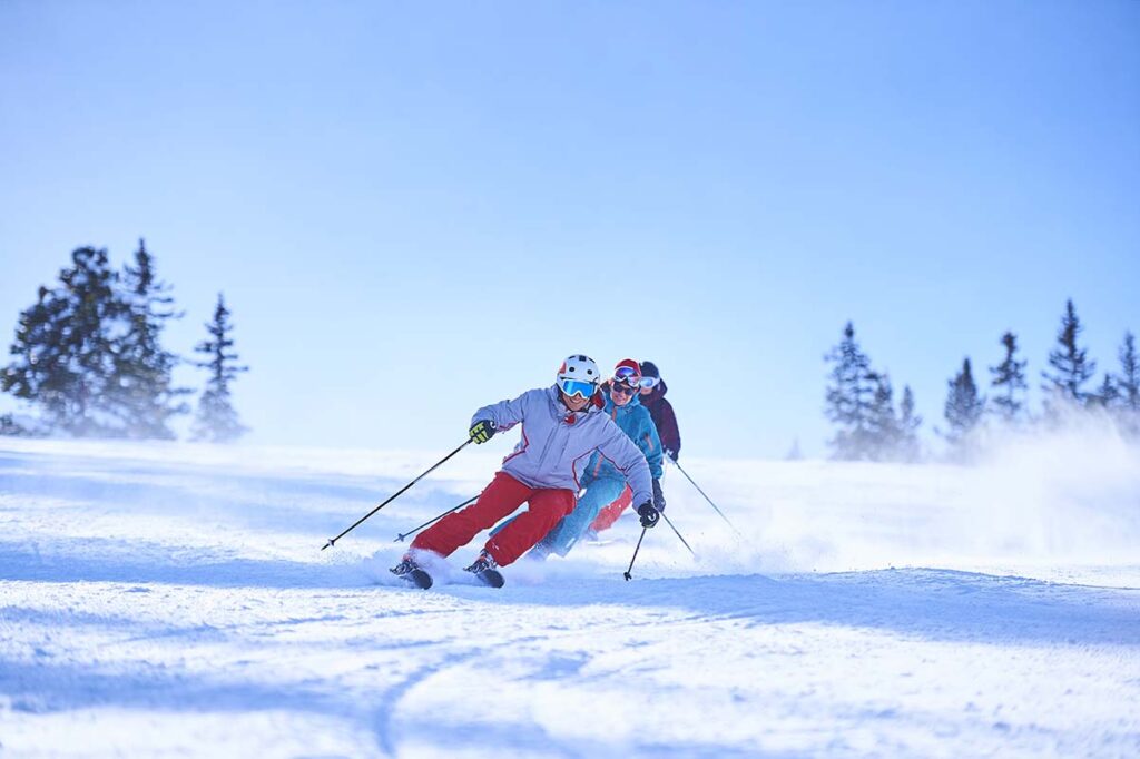 three skiiers in Aspen Co